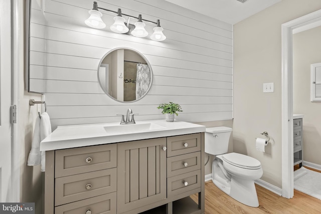 2224 Springwood Dr Unit 102A, Reston, VA 20191 - full bath with wood finished floors, toilet, wood walls, vanity, and baseboards