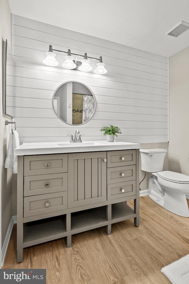 2224 Springwood Dr Unit 102A, Reston, VA 20191 - bathroom with wood finished floors, toilet, vanity, baseboards, and wooden walls