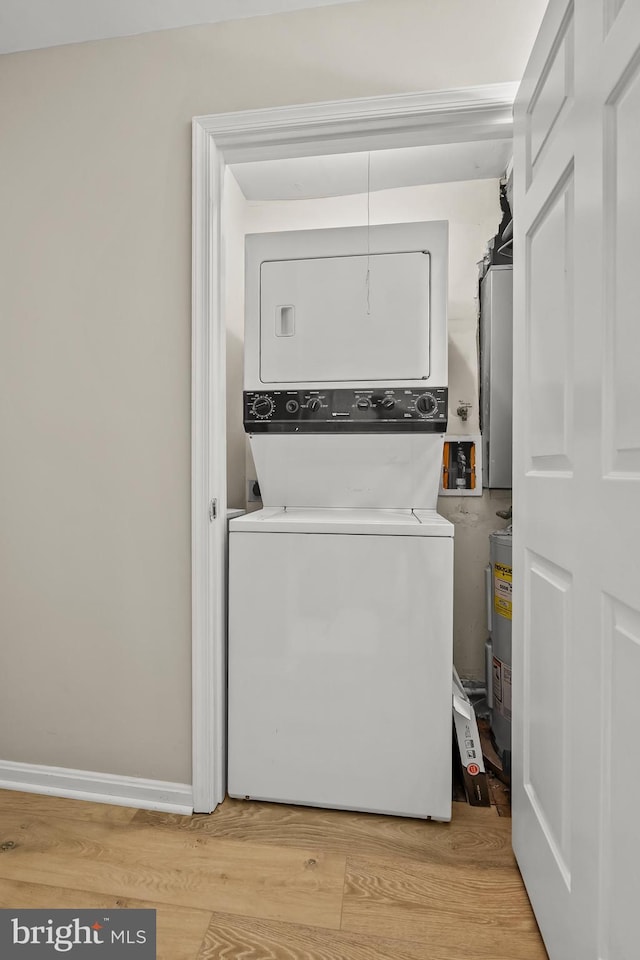 2224 Springwood Dr Unit 102A, Reston, VA 20191 - laundry room featuring stacked washer / drying machine, light wood-style floors, water heater, and baseboards