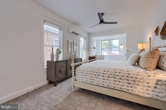 bedroom with a wall unit AC, carpet flooring, ceiling fan, and baseboards