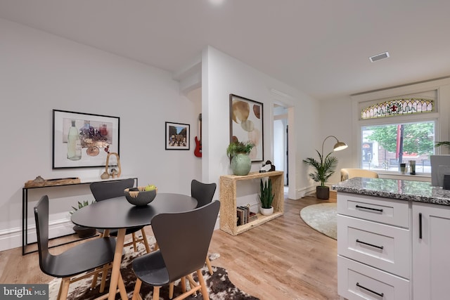 dining space featuring light wood-style floors and baseboards