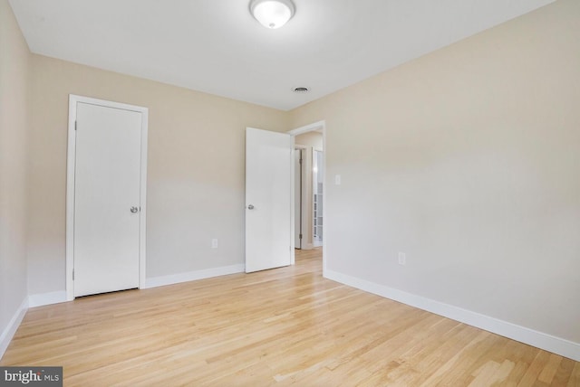 unfurnished room with baseboards and light wood finished floors