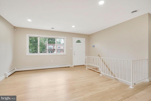 unfurnished room with light wood-style flooring, a baseboard heating unit, recessed lighting, and baseboards