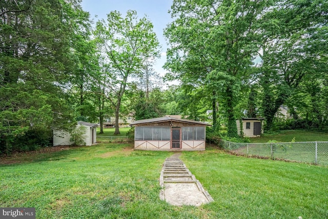 view of yard featuring a shed, a sunroom, and an outdoor structure