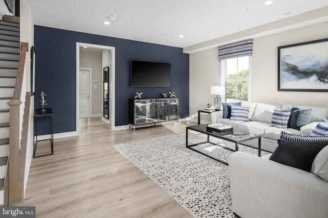 living room with stairs, light wood finished floors, recessed lighting, and baseboards