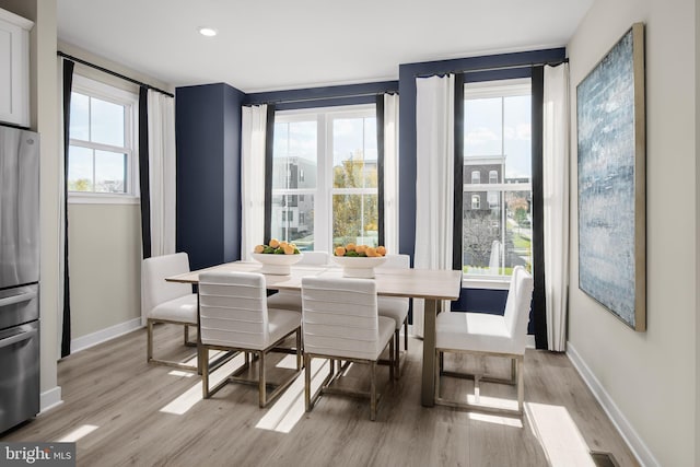 dining space with light wood-style flooring and baseboards
