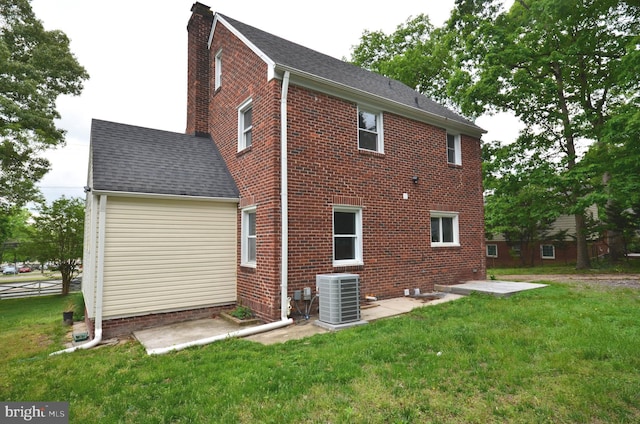 7009 Adelphi Rd, Hyattsville, MD 20782 - back of property with central AC unit, brick siding, a yard, and a shingled roof