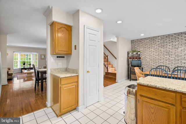 10938 Rocky Mount Way, Silver Spring, MD 20902 - kitchen with brick wall, recessed lighting, light stone countertops, baseboards, and light tile patterned floors