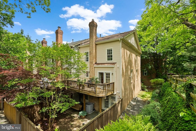 10938 Rocky Mount Way, Silver Spring, MD 20902 - back of property with a wooden deck, fence, cooling unit, and a chimney