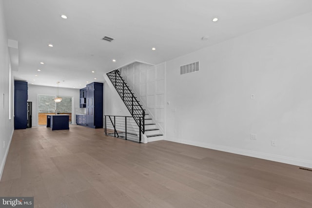 1615 S 22nd St, Philadelphia, PA 19145 - unfurnished living room with wood finished floors, stairway, recessed lighting, and baseboards