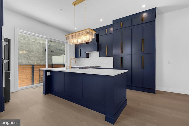 1615 S 22nd St, Philadelphia, PA 19145 - kitchen with a sink, blue cabinets, a chandelier, tasteful backsplash, and light countertops