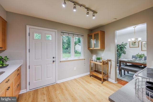 808 Gregorio Dr, Silver Spring, MD 20901 - foyer with light wood finished floors, a chandelier, baseboards, and rail lighting