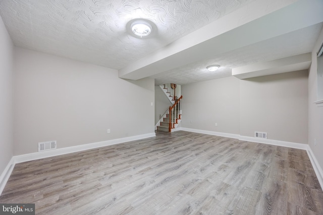 808 Gregorio Dr, Silver Spring, MD 20901 - finished basement featuring wood finished floors, baseboards, stairway, and a textured ceiling