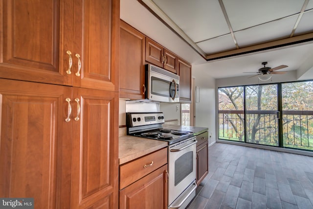 10300 Bushman Dr Unit 209, Oakton, VA 22124 - kitchen featuring stainless steel appliances, light countertops, brown cabinets, a ceiling fan, and baseboards