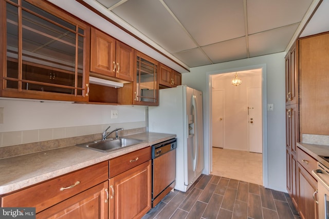 10300 Bushman Dr Unit 209, Oakton, VA 22124 - kitchen with dishwashing machine, a sink, brown cabinetry, a drop ceiling, and light countertops