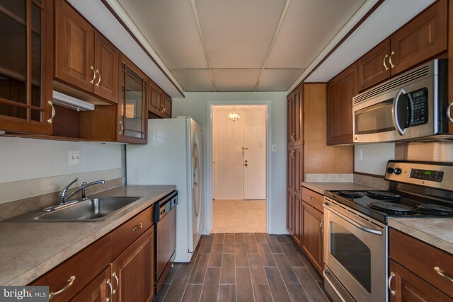 10300 Bushman Dr Unit 209, Oakton, VA 22124 - kitchen with stainless steel appliances, a sink, glass insert cabinets, dark wood-style flooring, and light countertops