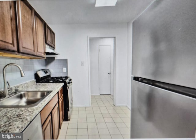 7212 Donnell Pl Unit B-5, District Heights, MD 20747 - kitchen with stainless steel appliances, under cabinet range hood, light tile patterned flooring, and backsplash