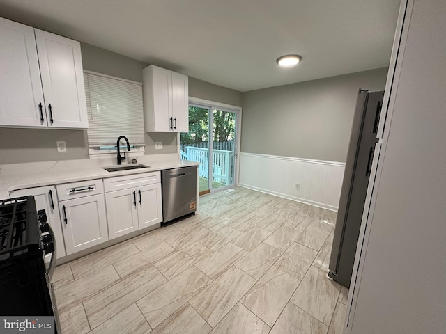 35 Preston Ave, Voorhees, NJ 08043 - kitchen with a sink, stainless steel appliances, wainscoting, white cabinets, and light marble finish flooring