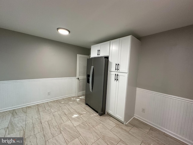 35 Preston Ave, Voorhees, NJ 08043 - kitchen with stainless steel fridge, a wainscoted wall, white cabinets, and light marble finish floors