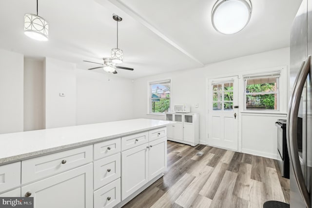 kitchen with freestanding refrigerator, ceiling fan, light wood-type flooring, white cabinetry, and decorative light fixtures