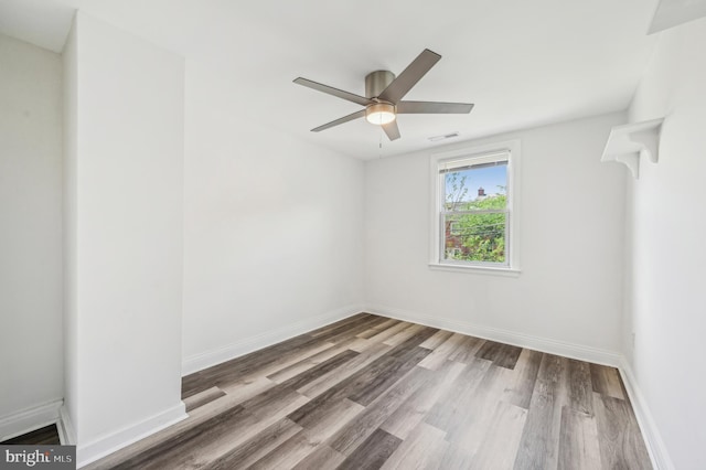 empty room featuring wood finished floors, ceiling fan, and baseboards