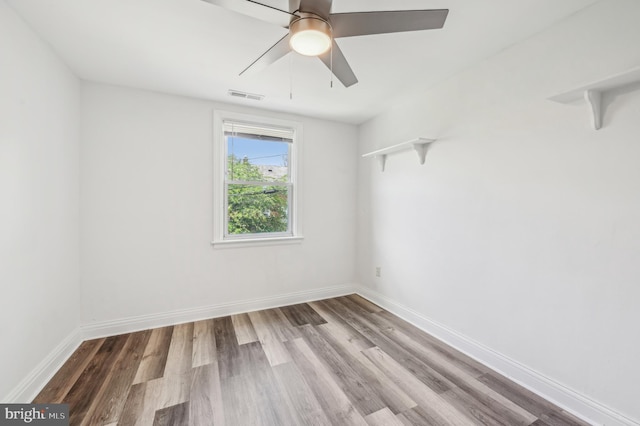 empty room with wood finished floors, baseboards, and ceiling fan