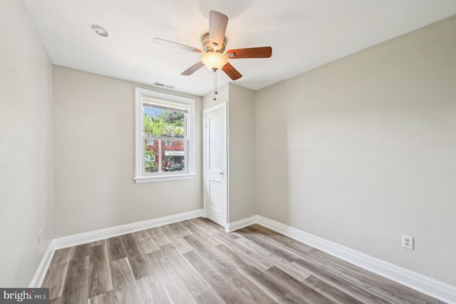 spare room featuring wood finished floors, ceiling fan, and baseboards