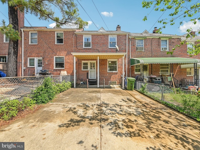 rear view of property with a fenced backyard, brick siding, and a chimney