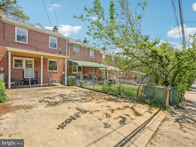 rear view of house with brick siding and fence