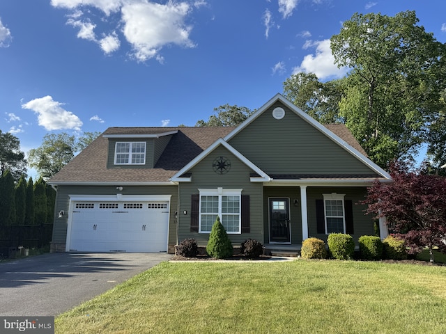craftsman inspired home featuring asphalt driveway, roof with shingles, a front yard, a porch, and an attached garage