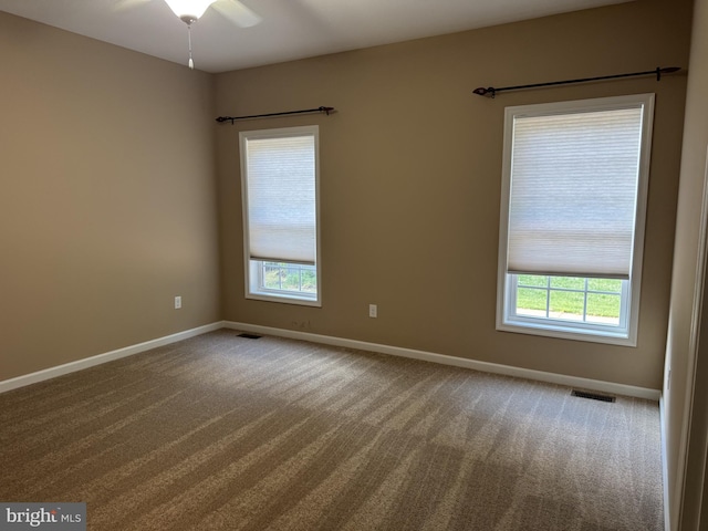 empty room with carpet, baseboards, and a ceiling fan