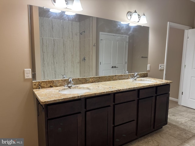bathroom featuring double vanity, tile patterned flooring, and tiled shower