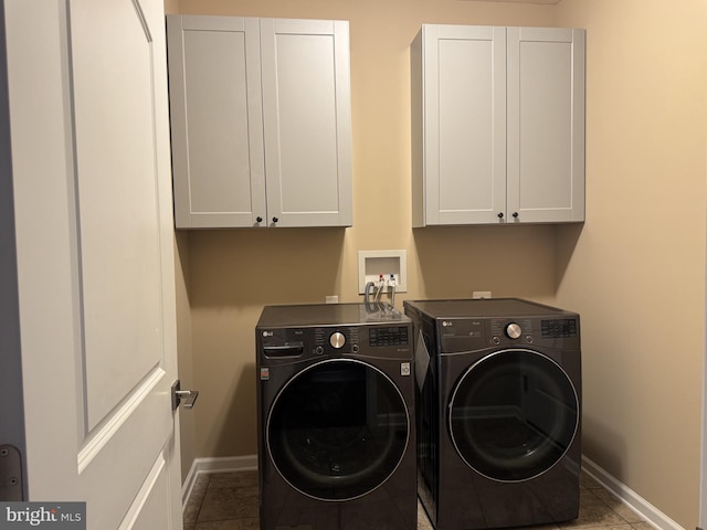 laundry room featuring cabinet space, baseboards, washer and clothes dryer, and tile patterned flooring