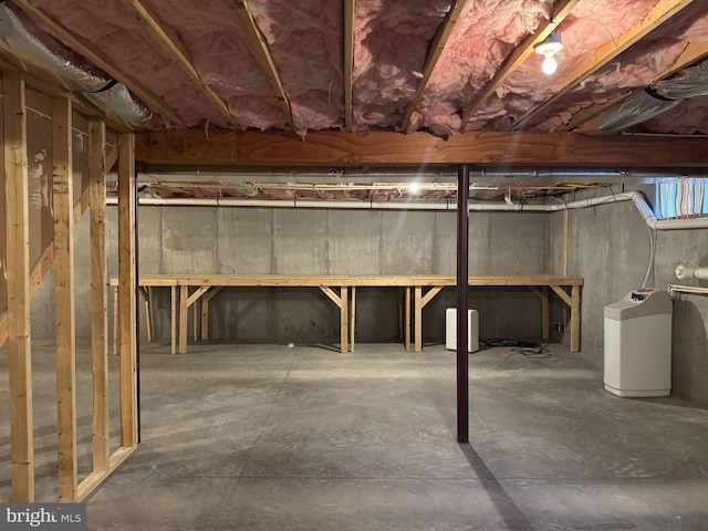 unfinished basement featuring a water softener system