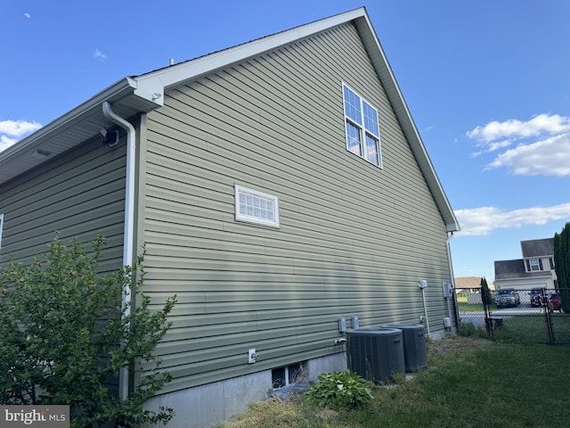 view of side of home with cooling unit and fence
