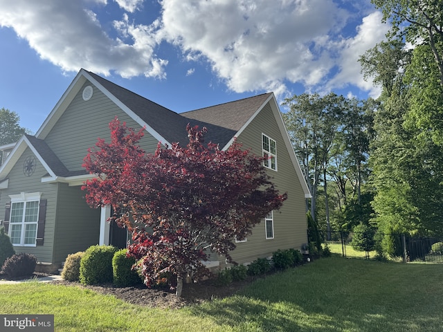 view of side of property with roof with shingles
