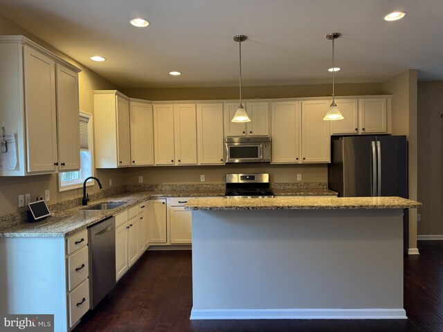 kitchen with appliances with stainless steel finishes, a sink, dark wood finished floors, white cabinets, and recessed lighting