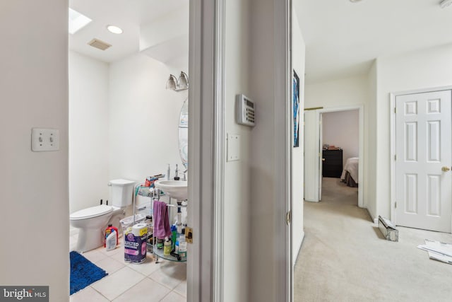 half bath with toilet and tile patterned floors