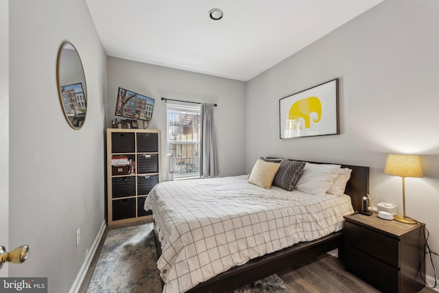 bedroom featuring baseboards and dark wood-type flooring