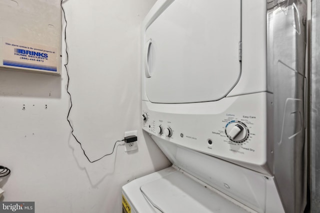 clothes washing area featuring stacked washer / drying machine