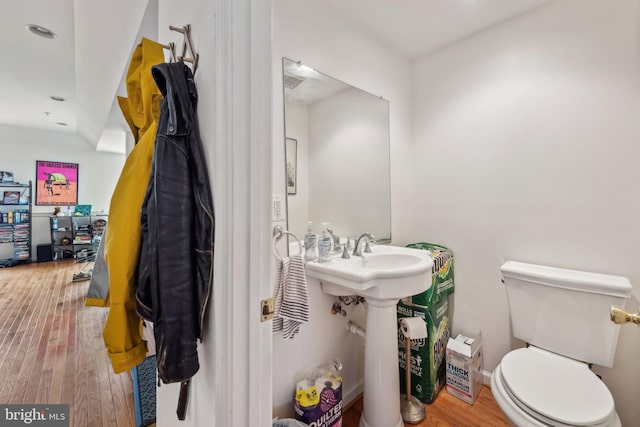 bathroom featuring wood finished floors, toilet, and recessed lighting