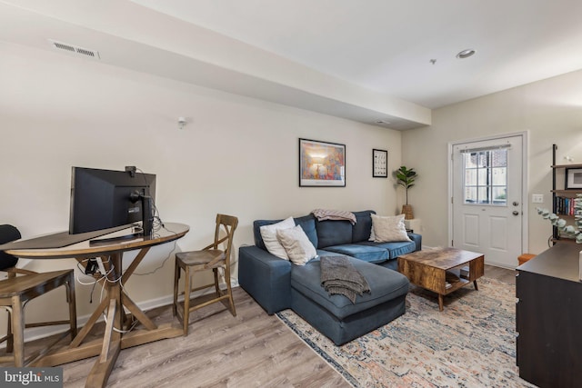 living area featuring light wood-style floors and baseboards