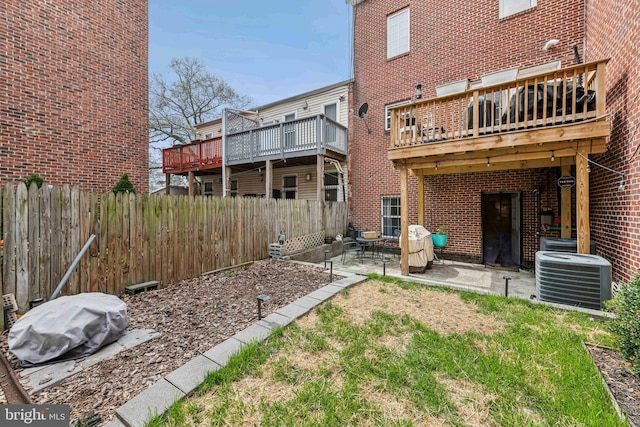 back of house with brick siding, a patio area, central air condition unit, and a fenced backyard