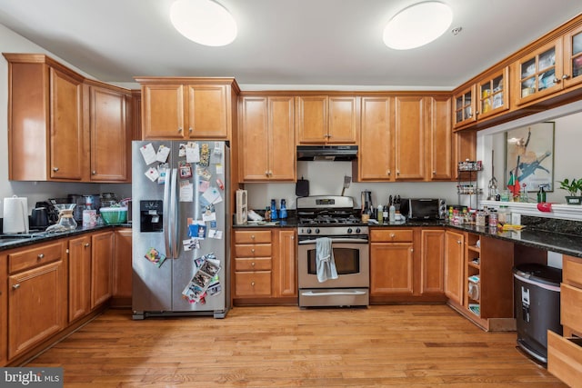 kitchen with appliances with stainless steel finishes, under cabinet range hood, light wood-style floors, and brown cabinetry