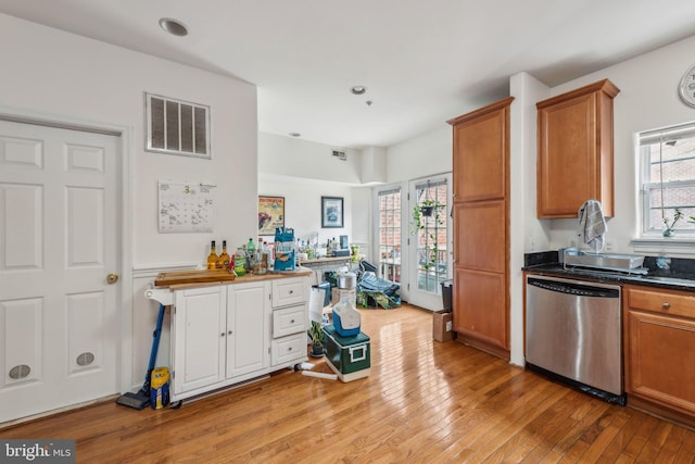 kitchen featuring dishwasher, light wood-type flooring, brown cabinetry, dark countertops, and recessed lighting