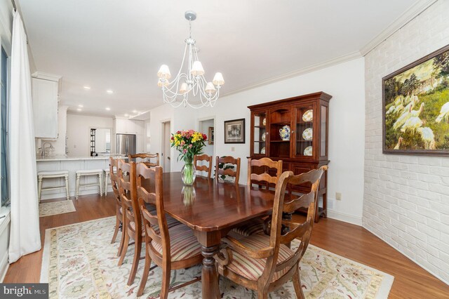 10 Highland Dr, Palmyra, PA 17078 - dining space featuring light wood-type flooring, brick wall, a chandelier, recessed lighting, and crown molding