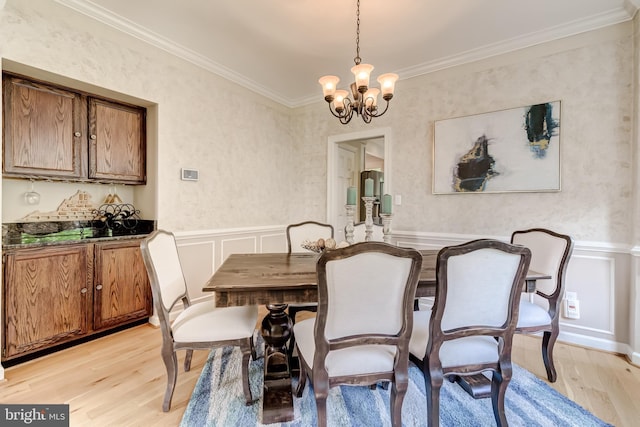 20932 Cox Mills Ct, Ashburn, VA 20147 - dining space featuring light wood finished floors, a chandelier, a decorative wall, ornamental molding, and a wainscoted wall