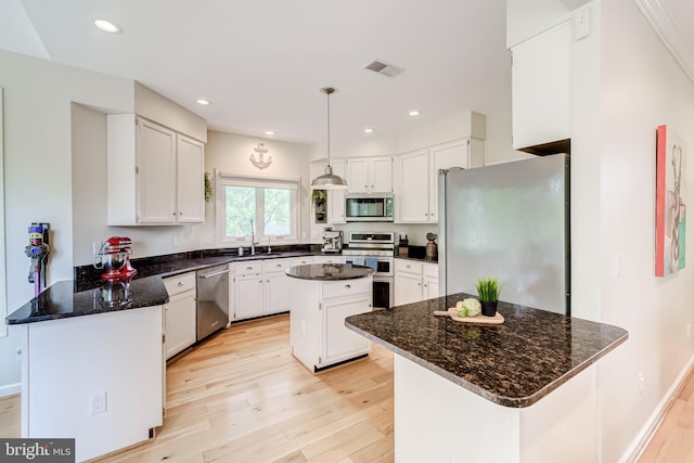 20932 Cox Mills Ct, Ashburn, VA 20147 - kitchen with stainless steel appliances, light wood-type flooring, a peninsula, white cabinetry, and recessed lighting