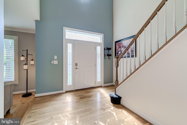 20932 Cox Mills Ct, Ashburn, VA 20147 - foyer featuring crown molding, stairs, light wood-type flooring, and a high ceiling