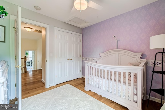 20932 Cox Mills Ct, Ashburn, VA 20147 - bedroom featuring wallpapered walls, wood finished floors, a closet, ceiling fan, and a nursery area